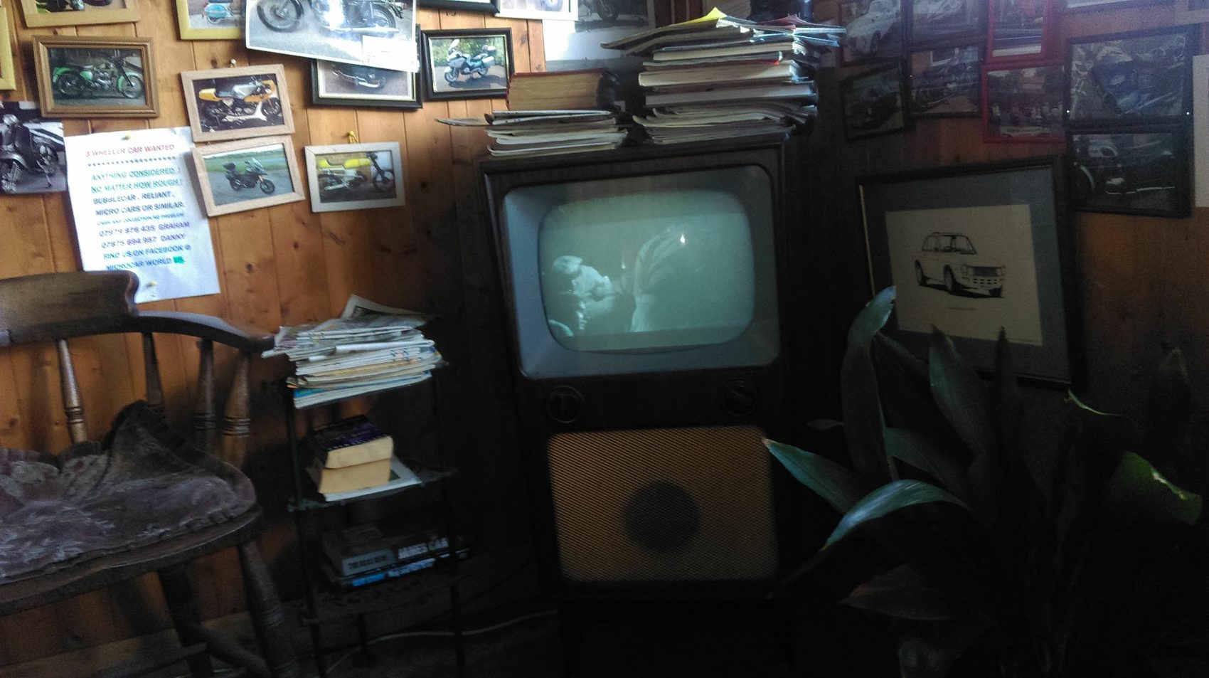 The office corner with an old television and walls of framed photographs